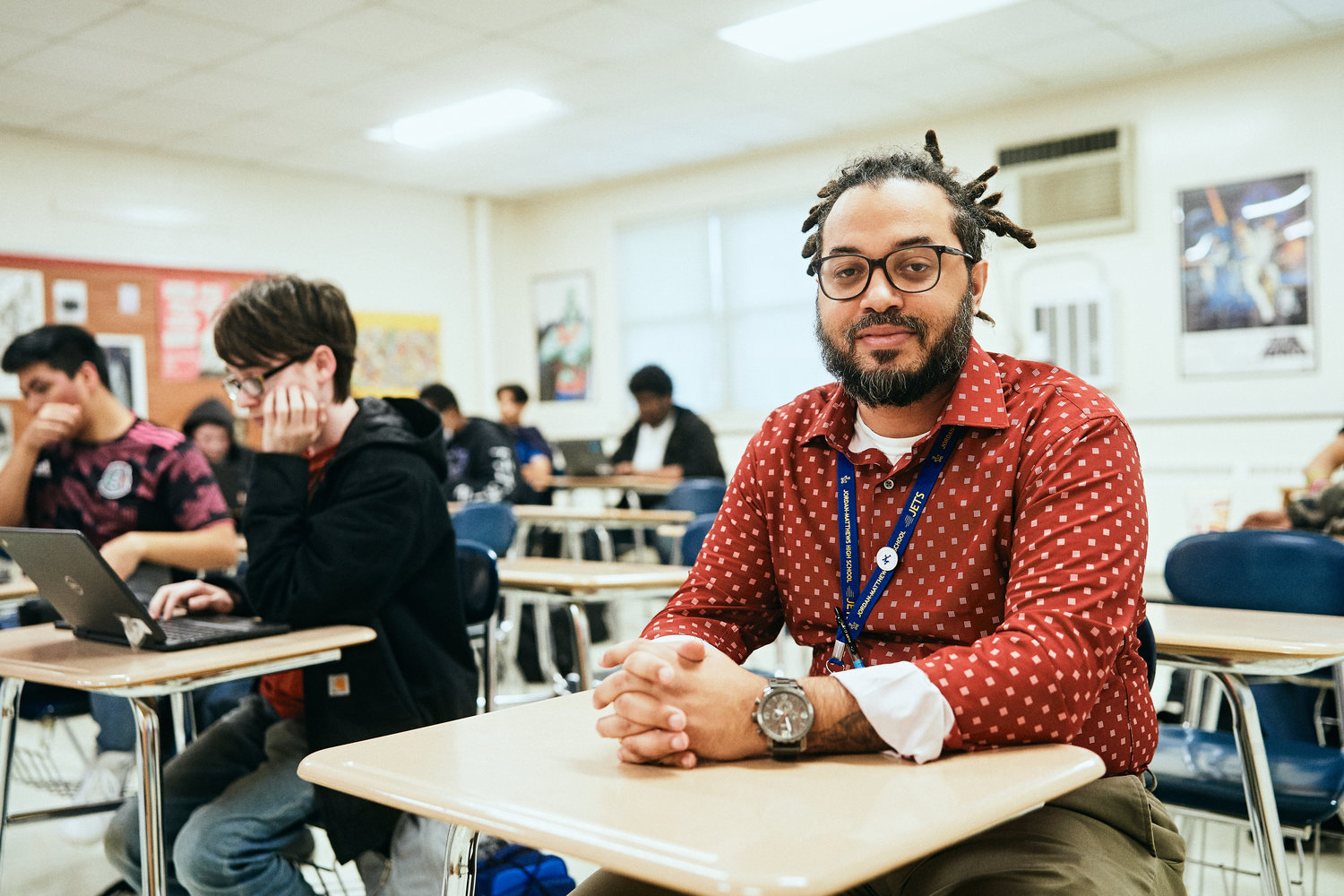 Travis Patterson, CIS employee, poses for a portrait at Jordan-Matthews High School in Siler City. He supervises after-school homework help sessions. 'It opens the doors for us to have very real conversations,' he said.
